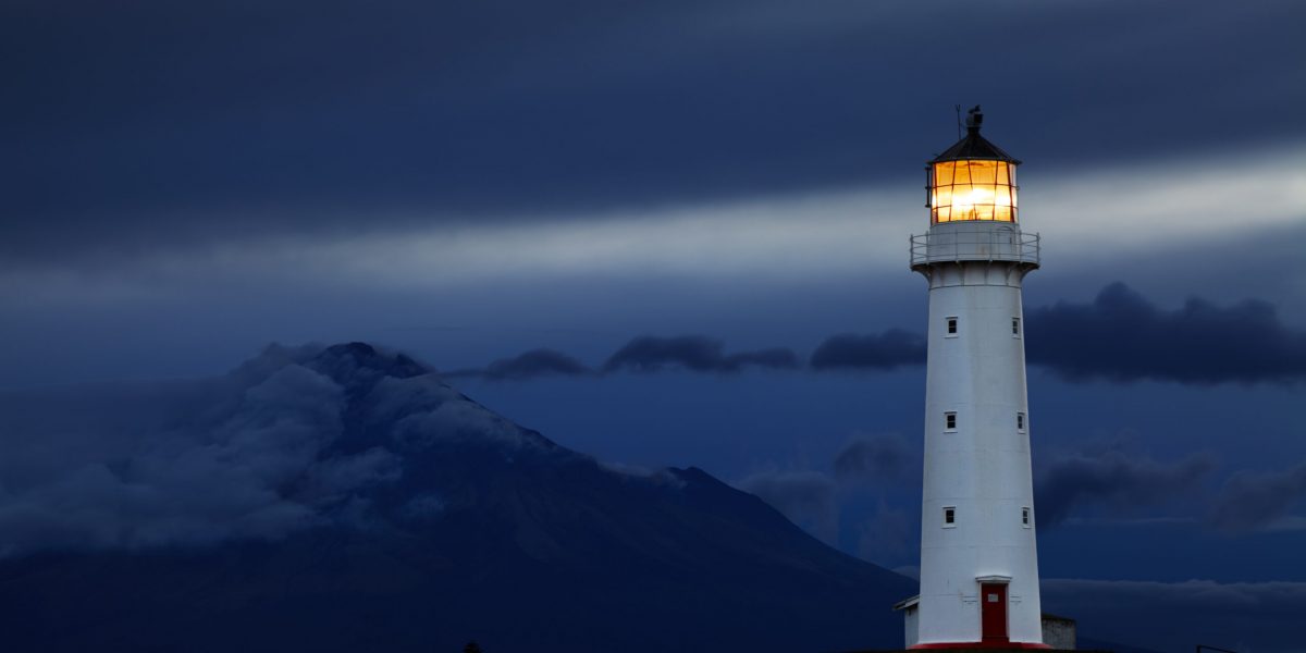 Cape Egmont Lighthouse and Taranaki Mount on background, New Zealand