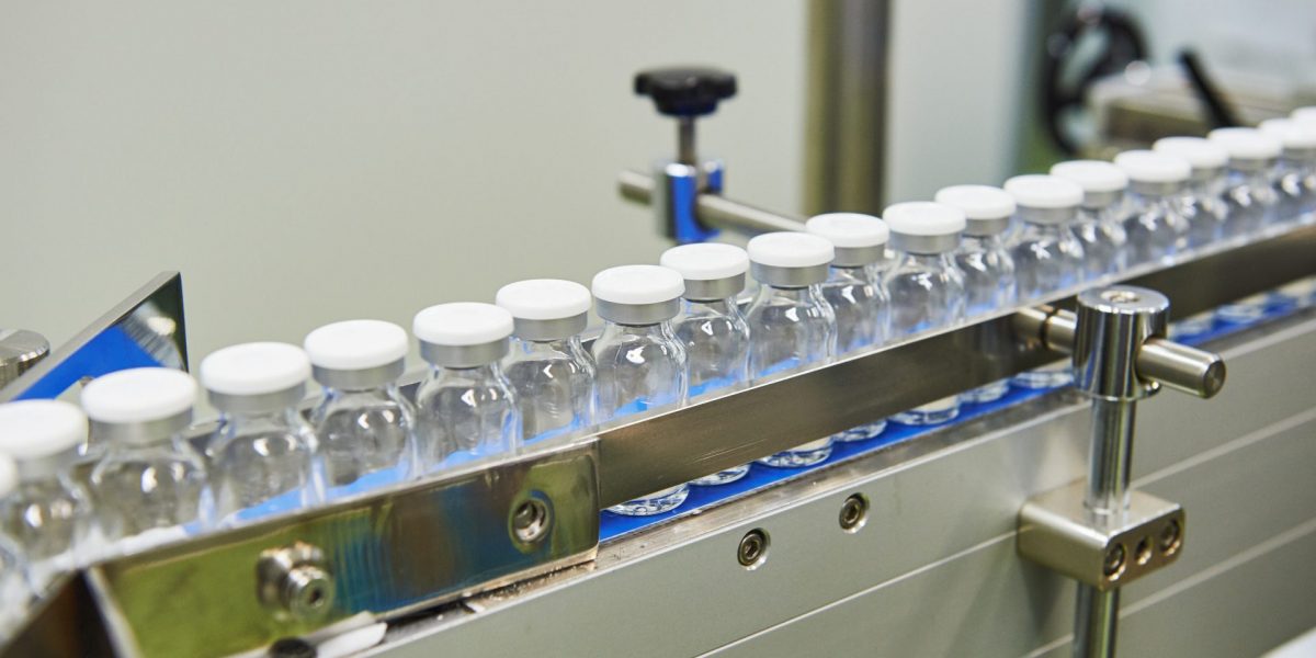 pharmaceutical industry. Production line machine conveyor with glass bottles ampoules at factory